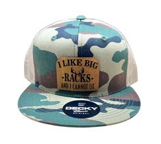 Introducing Big Racks - Flat Bill Trucker Hat in Camo/Khaki, the perfect accessory for outdoors enthusiasts. With its bold and unique design, this hat showcases your love for hunting and the great outdoors. The flat bill and mesh back offer both style and breathability. Show off your love for the wild with the Big Racks hat! Decky Snapback High Profile Trucker Hat with Flat Bill. Camo/Khaki Hat Featuring: A Bamboo style leatherette patch saying, “I like big racks and I cannot lie.” Great fit: fe Ponytail Hat, Wood Studs, Backpack Tags, Hat Patches, Ipad Sleeve, Wristlet Wallet, Custom Hats, Great Outdoors, Zipper Pouch