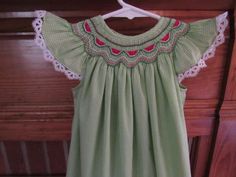 a green and white dress hanging on a wooden door