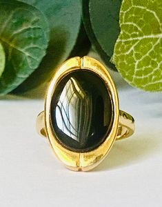 This is a wonderful vintage ring with a stunning jet black cab set in gold plate. It is marked 18 KT HGE and in excellent vintage condition.  Please be aware that we are not jewelry experts. We have a sincere love of all things vintage especially vintage jewelry. We hope to share our finds with you. That being said, we describe our items to the very best of our ability. Please view all photos and know that each phone or computer screen may display slightly different colors. Please ask any and all questions. We gladly accept returns and provide shop credit or refund upon receiving the item back. The buyer pays return shipping unless the item is grossly damaged. In that case, please send us a photo of the damage. Please contact us immediately with any order or item issues and we will gladly Black Cab, Black Stone Ring, Vintage Ring, Computer Screen, Black Stone, Ring Size 7, Stone Ring, Jet Black, Rings Statement