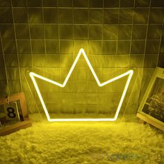 a neon crown sitting on top of a white rug next to pictures and a clock