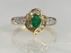 Emerald Ring, Emerald Ring Vintage, Emerald Ring Gold, Emerald Jewelry, Dainty Emerald Ring, Emerald Ring for Women, Emerald Diamond Ring A charming vintage emerald ring featuring an oval shaped center stone weighing 0.38 carats accented by 0.23 carats of diamonds set in solid 14k yellow gold. *Ring size: 6 3/4 *Ring weight: 3.25 Grams *Stone dimensions: 5X3mm Heirloom Emerald Ring With Diamond Accents For Anniversary, Elegant Collectible Emerald Ring With Center Stone, Elegant Emerald Ring With Center Stone For Collectors, Elegant Emerald Ring Collectible, Vintage Diamond Cluster Ring With Accent Stones, Vintage Yellow Gold Cluster Ring With Accent Stones, Vintage Emerald Ring With Accent Stones For Anniversary, Vintage Cluster Ring With Accent Stones For Formal Occasions, Vintage Emerald Ring With Center Stone For Anniversary