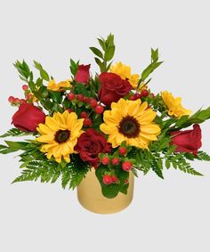 a vase filled with red roses and yellow sunflowers on top of a table