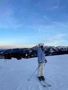 a person on skis standing in the snow with mountains in the backgroud