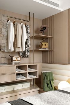 a bedroom with clothes hanging on the wall and closets in front of it,