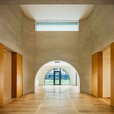 an empty room with large arched windows and wooden doors on either side of the wall