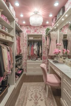 a walk in closet filled with lots of pink and white furniture next to a chandelier