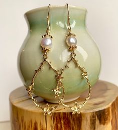 Enhance your boho chic style with this set of long gold teardrop-shaped flower branch dangly earrings. Featuring large gold-plated brass flower branch charms, these earrings are delicately crafted and exude a sweet charm. The handmade earring hooks, crafted with 10K gold-filled wire, add a touch of elegance. At the top, white freshwater pearls with gold-plated floral bead caps provide a classic and timeless accent. Measuring 2 1/2" X 7/8", including the gold-filled wire hooks, these earrings are a beautiful choice for Christmas gifts, birthdays, weddings, or any special occasion. Embrace the allure of boho chic with these intricate and stylish flower branch earrings. Elegant Teardrop Earrings With Flower Charm, Whimsical Gold Jewelry For Pierced Ears, Gold Whimsical Flower-shaped Earrings, Whimsical Gold Flower Earrings, Gold Teardrop Flower Charm Earrings, Gold Teardrop Flower Earrings With Charm, Delicate Teardrop Earrings With Ear Wire, Delicate Teardrop Chandelier Earrings, Teardrop Earrings With Flower Charm