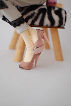 a woman's legs with high heels and zebra print shoes on top of a stool