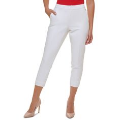 a woman in red shirt and white pants posing for the camera with her hands on her hips