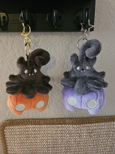 two stuffed animals hanging from hooks on a wall next to a carpeted area with a rug