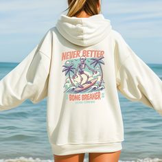 Never Better Surfing Skeleton Sweatshirt, Surfing Sweatshirt, Funny Hoodie, Beach Hoodie This unisex heavy blend hooded sweatshirt is relaxation itself. Made with a thick blend of cotton and polyester, it feels plush, soft and warm, a perfect choice for any cold day. In the front, the spacious kangaroo pocket adds daily practicality while the hood's drawstring is the same color as the base sweater for extra style points. .: Made with a medium-heavy fabric (8.0 oz/yd² (271 g/m that consists of 50 Hooded Sweatshirt With Letter Print For Surfing, Hooded Letter Print Sweatshirt For Surfing, Long Sleeve Hoodie With Letter Print For Surfing, Surfing Graphic Print Long Sleeve Hoodie, Surfing Skeleton, Never Better, Skeleton Sweatshirt, Beach Hoodie, Beach Room