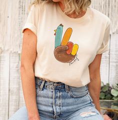 The first Picture is NATURAL color Keywords: Peace Turkey Shirt, Turkey Shirt for Thanksgiving, Thanksgiving Shirt for Turkey Lovers, Funny Thanksgiving Shirt, thanksgiving shirt, funny turkey, friendsgiving shirt, blessed and thankful, thankful shirt, black friday, family shirt, holiday shirt, fall shirt, turkey lovers, family shirt, christmas shirts, gift for him, thankful shirt, peace love turkey, turkey sign The First picture is Natural color ❤❤ SHIRT INFO❤❤ Our t-shirts are SUPER soft and SUPER comfy. Sleeves are only rolled for the picture. Solid Colors: 100% combed and ring spun cotton, 30 single ,4.2 oz. Heather/Blend Colors: 52% combed and ring spun cotton, 48% polyester, 30 single, 4.2oz Brands that WE USE: Crew Neck: Bella Canvas, Gildan and Next Level Baby and Toddler: Rabbin S Friendsgiving Shirt, Turkey Lover, Thankful Turkey, Retro Thanksgiving, Thanksgiving Sweatshirt, Funny Thanksgiving Shirts, Heat Press Printing, Thankful Shirt, Funny Turkey