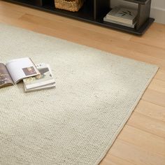 an open magazine sitting on top of a rug next to a book shelf with books