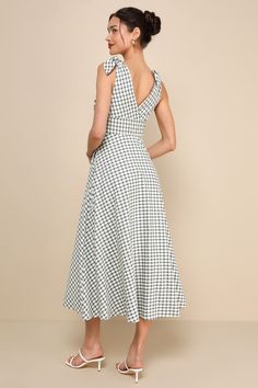 Life is like a picnic when you look oh-so-cute in the Lulus Sweetest Posture Navy and Cream Gingham Tie-Strap Midi Dress With Pockets! Lightweight cotton-blend fabric, with a darling gingham print in hues of cream and blue, falls from tying sash straps into a flattering surplice neckline (and back) and a fitted bodice with gathered details. The high, banded waist sits atop a twirl-worthy, skater skirt that features side seam pockets and finishes at a timeless midi hem. Hidden side zipper/clasp. Chic Sleeveless Plaid Dress For Picnic, Sleeveless Cotton Plaid Dress For Picnic, Chic Sleeveless Gingham Plaid Dress, Chic Gingham Sleeveless Dress, Chic Midi-length Plaid Dress For Picnic, Chic Cotton Plaid Midi Dress, Chic Midi Length Plaid Dress For Picnic, Chic Sleeveless Plaid Dress, Spring Garden Party Gingham Plaid Dress