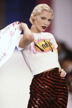 a woman is walking down the runway wearing sequin pants and a t - shirt