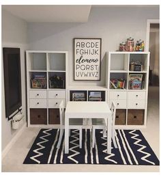 a white table sitting in the middle of a living room next to a book shelf