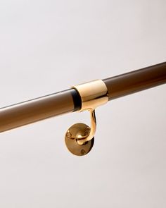 a close up view of a gold colored curtain rod with a hook on the end