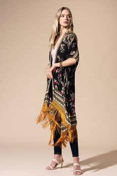 Stunning floral print with ethnic border featuring fine tassel kimono with side slits free size *100% Viscose *APPROX. L 37.50" W 39.5" Fringe L 7.50" 9.49oz *Imported Traditional Kimono For Spring Beach Cover-up, Traditional Printed Kimono For Beach Cover-up, Fall Beach Kimono With Tassels, Fringe Kimono For Beach In Fall, Spring Kaftan With Tassels And Kimono Sleeves, Spring Folk Long Kimono, Beach Kimono With Tassels One Size, Vacation Kimono With Tassels One Size, Bohemian Fringe Kimono One Size