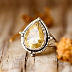 Crafted from gleaming sterling silver, this ring showcases a mesmerizing teardrop-shaped citrine gem, adding a touch of warmth and brightness to any outfit. The delicate band and simple design make it perfect for stacking or wearing solo. This ring features a natural, genuine, unique gemstone handpicked from our current collection. The actual gemstone you receive will be one-of-a-kind and may be different from the photos, making your ring truly special. ❥ Metal: Solid sterling silver ❥ US Ring Size: Choose Size ❥ Width: 20mm ❥ Gemstone: Citrine ❥ Gemstone Color: Yellow ❥ Gemstone Size: 15mm Yellow Stone Rings, Moonstone Ring Sterling Silver, Pear Ring, Citrine Jewelry, Teardrop Ring, Golden Glow, Gem Ring, Citrine Ring, New Year Gift