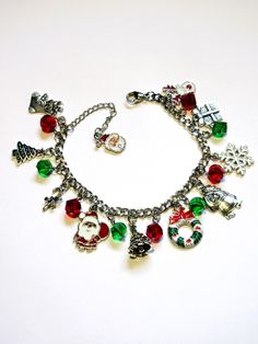 Christmas charms are attached to a stainless steel chain for a 7 inch, adjustable to 8 inch, charm bracelet. The charms are interspersed with red and green, 8mm, spiral faceted crystals. A Santa charm is added to the end of the extender chain. The charms include Santa, Christmas trees, a wreath, a snowflake, a reindeer, and more. This bracelet will be slipped into an organza bag and shipped in a bubble mailer. Christmas Festive Silver Charm Bracelet, Christmas Festive Jewelry With Charms, Christmas Festive Charms Jewelry, Christmas Festive Jewelry Charms, Silver Christmas Festive Bracelets, Silver Charm Bracelets For Christmas, Silver Bracelets For Christmas Festive Season, Festive Silver Bracelets For Christmas, Nickel-free Jewelry For Festive Holidays