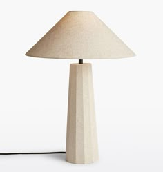 a wooden lamp with a white shade on it's base and a black cord