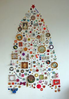 a christmas tree made out of many different pictures and magnets on the side of it