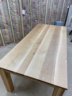 a wooden table sitting in front of a pile of pallet paper on the floor