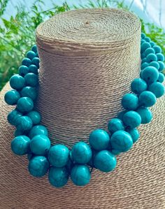 Make a statement with this Turquoise multi beaded Necklace. Made with various sized round beads threaded on black cotton.  Fastens with a metal hook. Measures: 45 cm. HANDMADE & FAIRTRADE. Other colours are available in this necklace. Please look at our shop to find other colour options.Items posted to addresses within the UK will be sent Royal Mail 1st Class UK Standard. Overseas by Royal Mail International Tracked and Signed. Turquoise And Black Beads Necklace For Jewelry Making, Turquoise Jewelry With Round Wooden Beads, Turquoise Necklace With Large Beads, Turquoise Necklace With Large Round Beads, Beaded Turquoise Necklace With Round Beads, Turquoise Wooden Beads For Jewelry Making, Turquoise Multi-strand Beaded Necklace With Large Beads, Turquoise Beaded Necklaces With Round Beads, Adjustable Turquoise Necklace With Round Beads