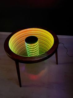 a table with a lit up basket sitting on it's side, in the middle of a room