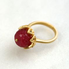 A stunning and luminous 12mm raspberry red ruby stone is set into a 22k gold over sterling vermeil setting. This stone absolutely glows from every single angle. The size is fully adjustable on the very comfortable band. An absolute one and only fine gemstone ring. Elegant Adjustable Gold Ruby Ring, Adjustable Elegant Ruby Ring, Adjustable Formal Ruby Gemstone Ring, Adjustable Gold Ruby Ring, Spiritual Gold Rings With Ruby, Spiritual Gold Ruby Rings, Gold Faceted Ruby Ring, Gold Faceted Ruby Ring For Anniversary, Adjustable Yellow Gold Ruby Ring