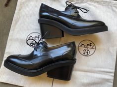 Authentic Hermes Tuscan Calfskin Nadege 70 Derby Pumps. In excellent condition; like new with dust bags and never worn. MSRP was 980$-1250$. Calfskin black upper with thick rubber or similar sole and chunky almost wedge heel. Size 37 (7). Made in Italy. The insole is approximately: 9.75" Across ball width: 3.25" outsole heel height: 3.25" platform: 0.75" Luxury Wedge Heels For Office, Luxury Office Wedge Heels, Designer Wedge Heel For Formal Occasions, Oxford Platform Shoes, Chunky Wedges, High Heel Wedges, Gorgeous Clothes, Leather Lace, Platform Shoes