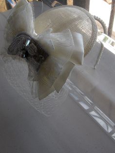 This Ivory Ribbon Lace Crystal Bow Sinamay Fascinator Hat with Veil and Pearl Headband is a beautiful accessory for weddings, bridesmaid, parties, and other special occasions. It is elegant, stylish, romantic, and super chic! Will definitely add a sparkling touch to your outfit!! I only accept PayPal and ship all orders within 24 hours via USPS. Feel free to send me a convo with any questions. Thank you for visiting Hettie Hair Accessories! Elegant Bridal Accessories With Satin Bow, Elegant Wedding Hats With Satin Bow, White Gatsby Style Fascinator For Evening, Elegant Ribbon Headband For Wedding, Elegant Adjustable Headpieces With Ribbon, Adjustable Vintage Fascinator For Wedding, Elegant Wedding Hair Accessories With Ribbon, Elegant Wedding Hat With Bow, Elegant Beige Wedding Headpieces