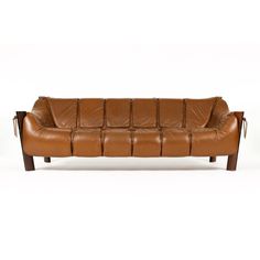 a brown leather couch sitting on top of a white floor next to a wooden frame