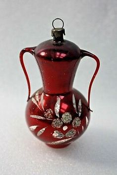 a red glass vase sitting on top of a white table