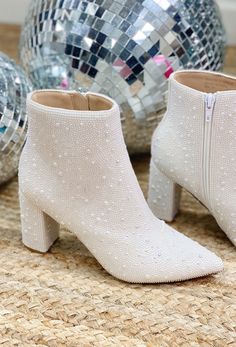 a pair of white boots sitting on top of a floor next to disco balls and mirrors