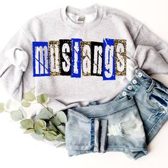 a sweatshirt with the word mustangs printed on it next to ripped jeans and flowers