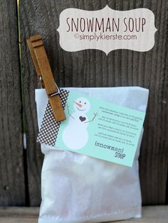 a snowman soap bar sitting on top of a white bag next to a wooden fence