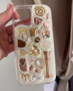 a person holding up a phone case with various items on it