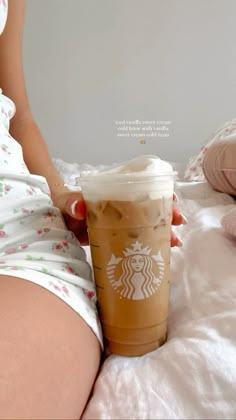 a woman is holding a starbucks drink on her stomach