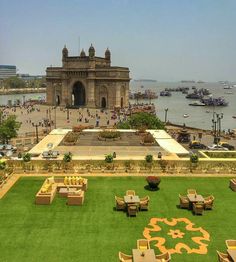 an aerial view of the city with many tables and chairs in front of some water