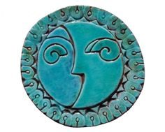 a blue ceramic plaque with an image of a woman's face in the center