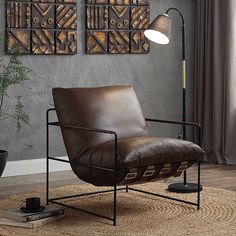 a brown leather chair sitting on top of a rug next to a lamp and potted plant