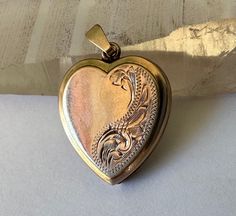 "a sweet gold locket, not tiny, with victorian style engraving and places for photos.  it's marked 9ct bk and ft, which i believe means the faces are gold but the inside is not.  it has the little heart inserts that hold the photos are there, although they have some kinks from being moved in and out, also the little plastic windows are there.  heart has a few tiny dents and some very light scratching but basically looking good.  closes well. toatl height:  a bit under 1 and 1/8\" height of heart Victorian 14k Gold Heart-shaped Jewelry, Victorian 14k Gold Heart Shaped Jewelry, Victorian 14k Gold Heart Jewelry, Heirloom Engraved Locket Necklace For Valentine's Day, Victorian Engraved Rose Gold Locket Necklace, Antique Heart-shaped Engraved Jewelry, Victorian Engraved Heart Jewelry, Antique Etched Heart Jewelry, Antique Etched Heart-shaped Jewelry