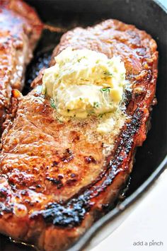 two steaks in a skillet with butter and herbs on the top, ready to be eaten