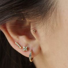 a close up of a person's ear with three piercings