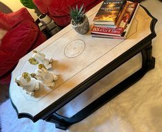 a coffee table with some books on it and a potted plant in the middle