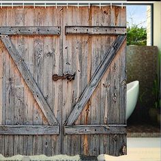 an old wooden barn door is shown in this bathroom shower curtain set with hooks on the side