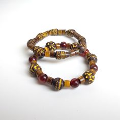 Elevate your style with this striking set of two handmade bracelets, crafted with a blend of tribal wood beads, vibrant red agate, and mesmerizing tiger's eye. Sized at 7 inches, these bracelets offer a perfect balance of natural earth tones and rich, bold colors, making them an ideal accessory for any occasion. Design Features: Tribal Wood Beads: Add a rustic and earthy touch with these unique beads that bring a sense of grounded authenticity. Red Agate: Known for its protective and calming properties, red agate beads infuse the bracelets with vibrant energy. Tiger's Eye: A stone of confidence and strength, tiger's eye adds a dynamic contrast with its captivating, shimmering hues. Wear them together for a stacked look, or separately for a more subtle statement. Whether you're dressing up Traditional Brown Beaded Bracelets With Natural Stones, Spiritual Wooden Beads Bracelets For Festivals, Traditional Brown Beaded Bracelet With Natural Stones, Brown Bohemian Bracelets For Festivals, Traditional Wooden Beads Bracelets For Festival, Traditional Adjustable Beaded Bracelets With Wooden Beads, Traditional Wooden Beads Bracelet For Festival, Adjustable Traditional Beaded Bracelet With Wooden Beads, Traditional Adjustable Wooden Beaded Bracelets