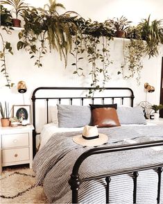 an instagram photo of a bedroom with plants on the wall and bed in it