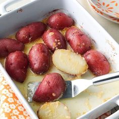 a white dish filled with potatoes on top of a table